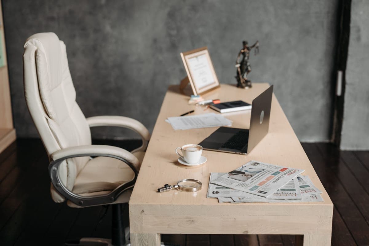 A wooden desk and chair in a tidy workspace