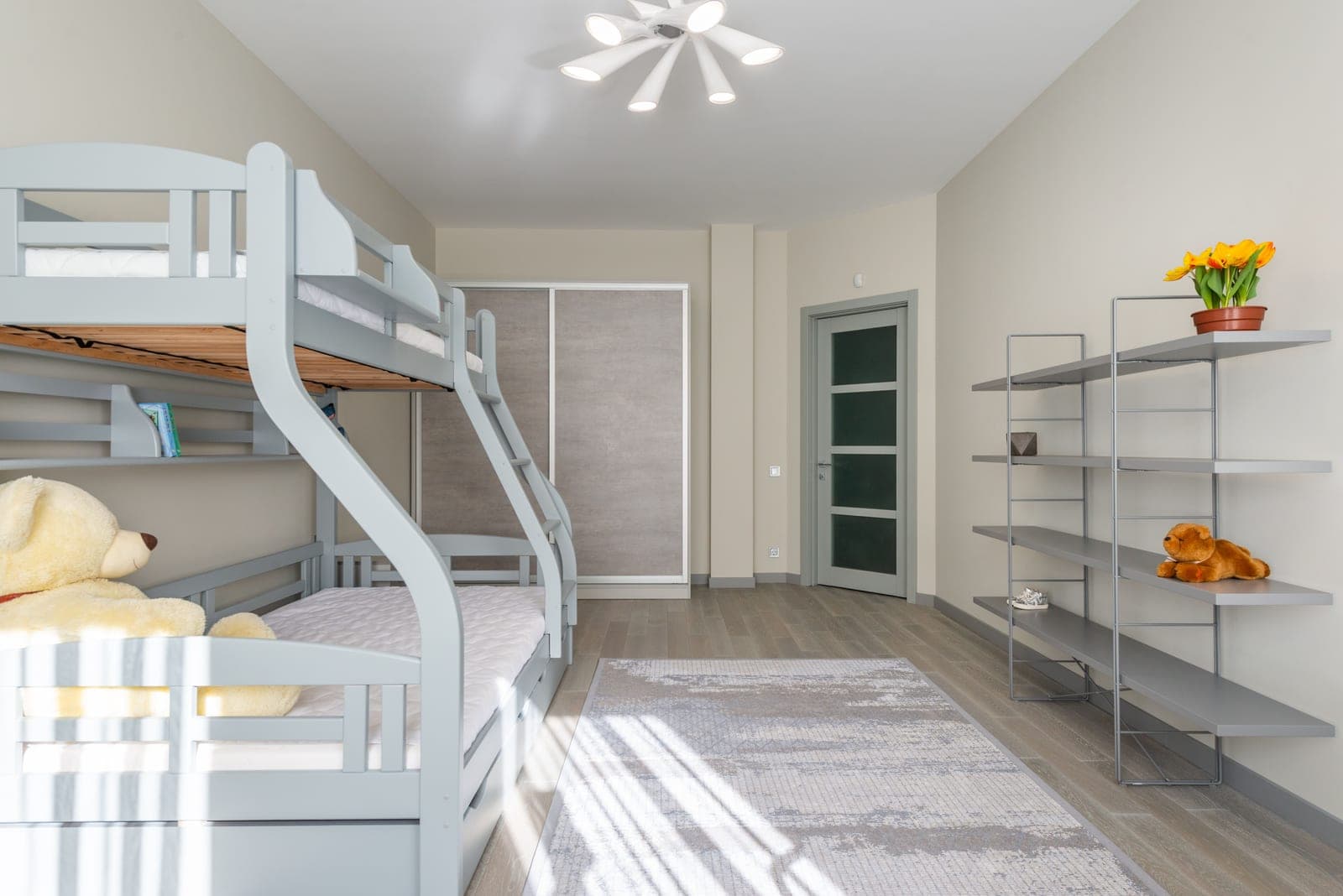 A modern children's bedroom with a wooden bunk bed